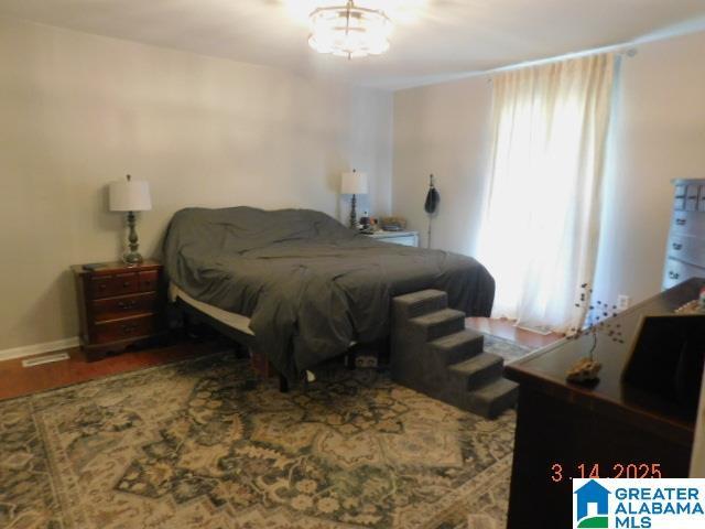 bedroom with wood finished floors and baseboards