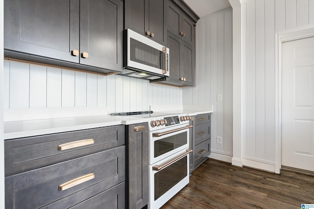 kitchen with white appliances, gray cabinetry, dark wood-style flooring, and light countertops