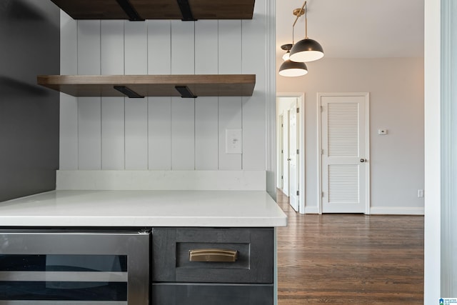 kitchen with beverage cooler, baseboards, dark wood-style flooring, light countertops, and pendant lighting