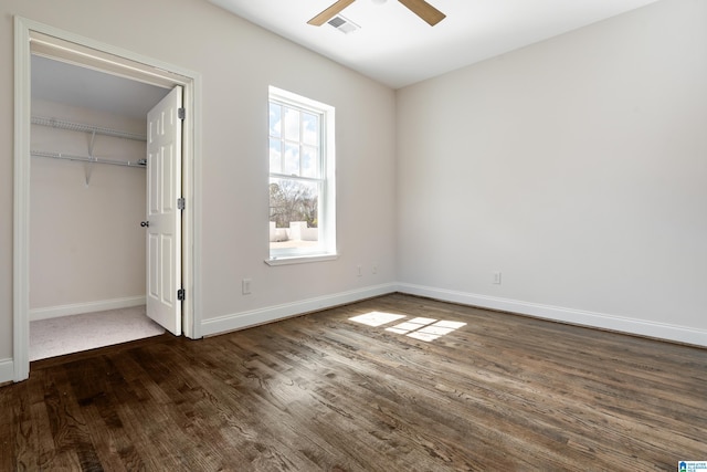 unfurnished bedroom featuring visible vents, dark wood-type flooring, baseboards, a closet, and a ceiling fan