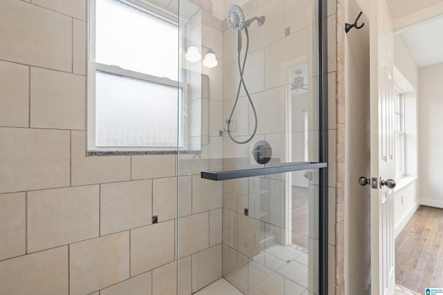 bathroom with a shower stall and wood finished floors