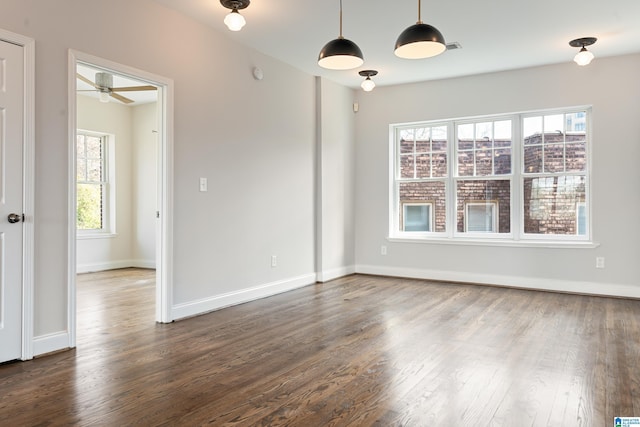 spare room with dark wood-type flooring, baseboards, and ceiling fan