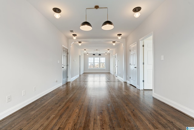 interior space with visible vents, baseboards, and dark wood-style flooring