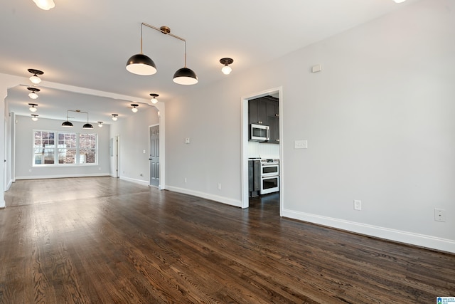 unfurnished living room with baseboards and dark wood-style flooring