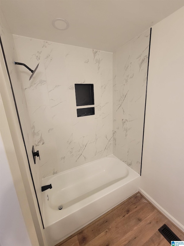 bathroom with visible vents, baseboards, bathtub / shower combination, and wood finished floors