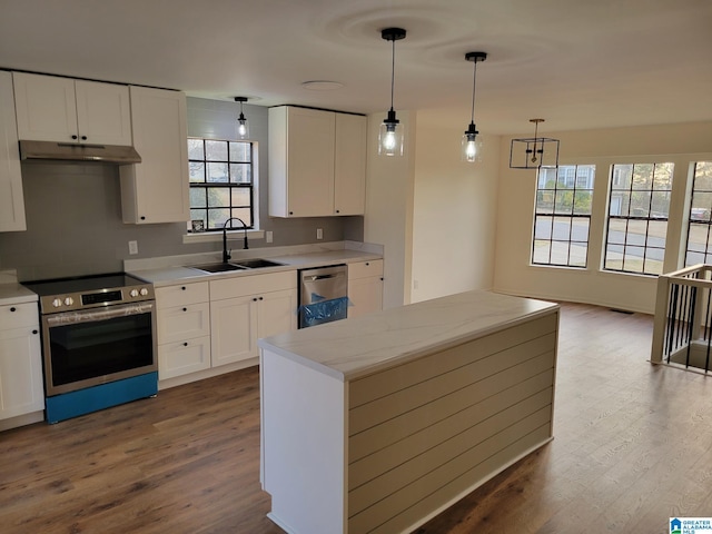 kitchen with a sink, stainless steel appliances, dark wood-type flooring, and under cabinet range hood