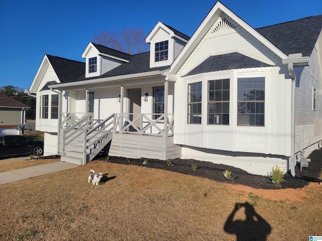 view of front of property with a porch and a shingled roof