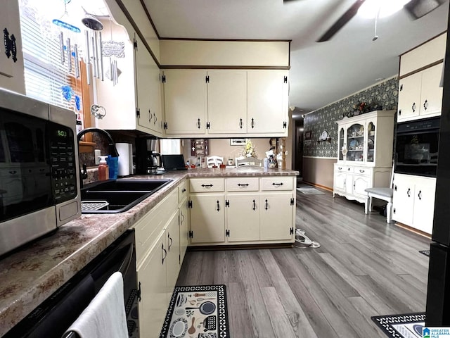282 Stewart Rd, Cullman, AL 35055 - kitchen featuring wood finished floors, wallpapered walls, a sink, stainless steel microwave, and black oven