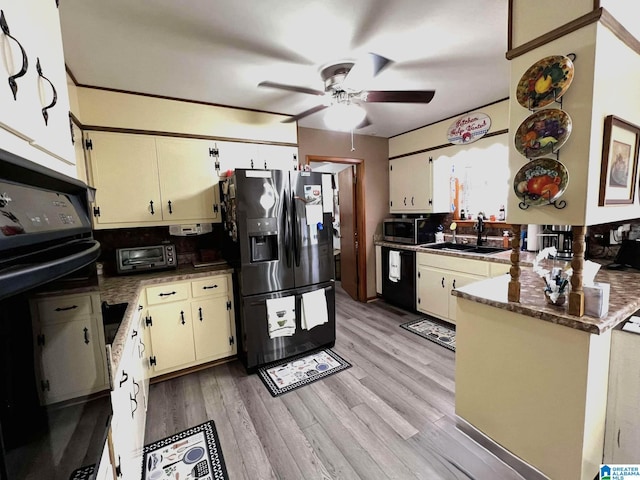 282 Stewart Rd, Cullman, AL 35055 - kitchen featuring a ceiling fan, light wood finished floors, a peninsula, a sink, and black appliances