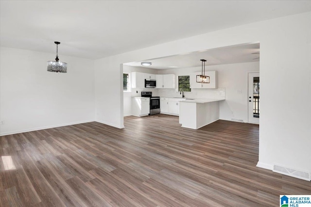 unfurnished living room with visible vents, dark wood-style flooring, baseboards, and a sink