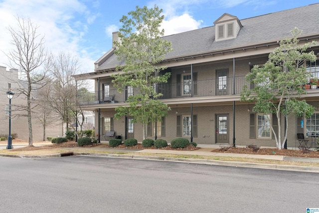 exterior space featuring brick siding and a balcony