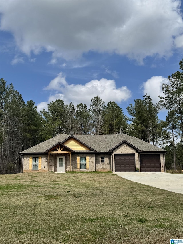 view of front of home featuring an attached garage, driveway, and a front yard