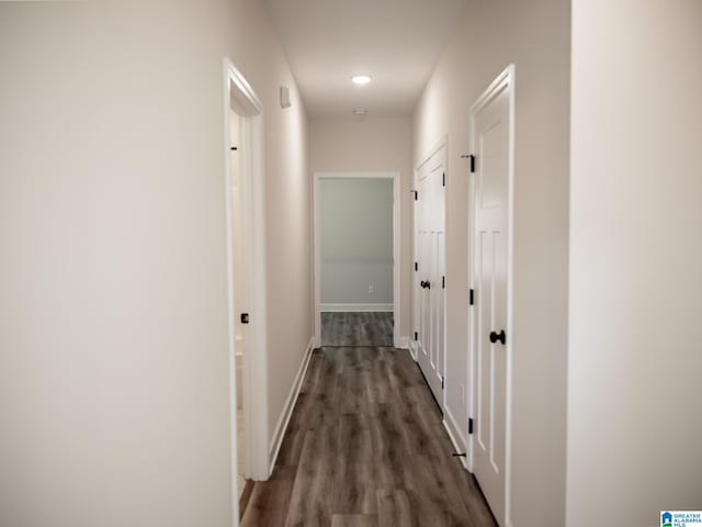 hall with baseboards and wood finished floors