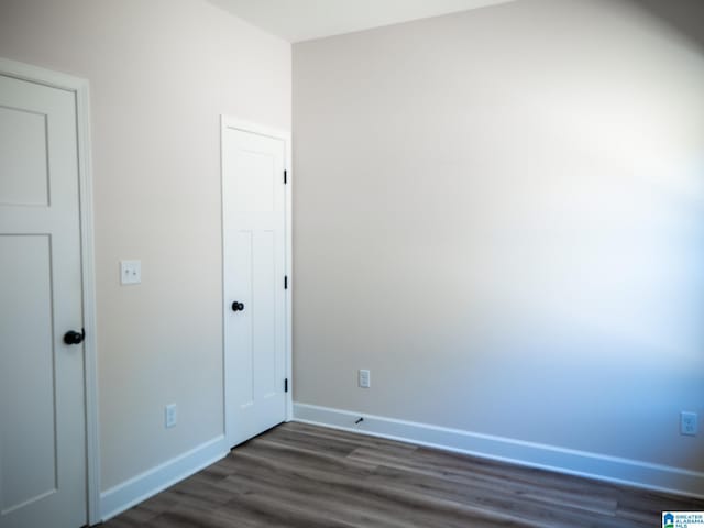 unfurnished bedroom featuring dark wood finished floors and baseboards