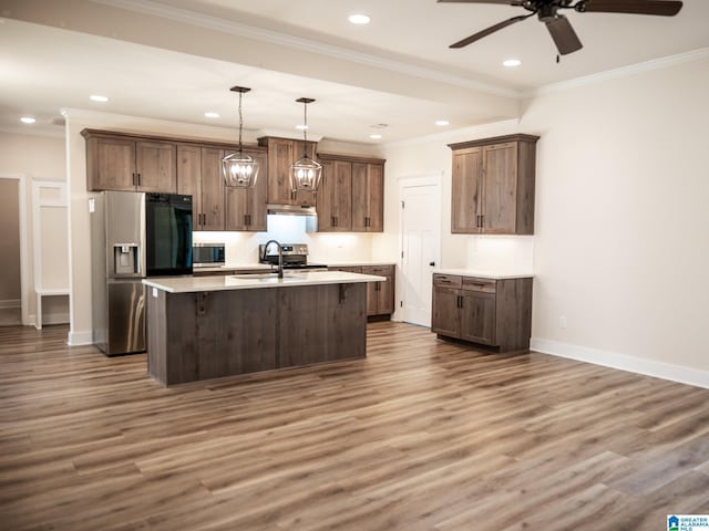 kitchen with wood finished floors, a ceiling fan, baseboards, a kitchen island with sink, and appliances with stainless steel finishes