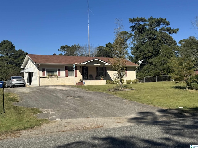 ranch-style home with a front lawn, fence, and driveway