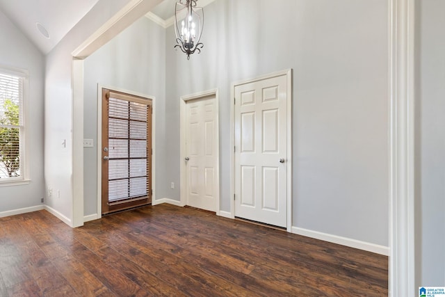 entryway with vaulted ceiling, an inviting chandelier, baseboards, and dark wood-style flooring