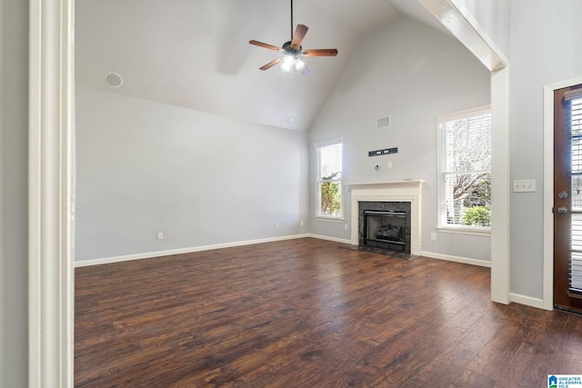 unfurnished living room with baseboards, a fireplace with flush hearth, dark wood-style floors, high vaulted ceiling, and a ceiling fan