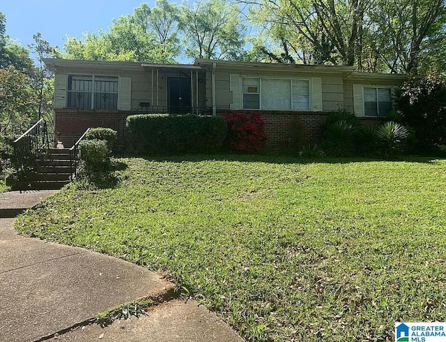 view of front of house with a front lawn and brick siding