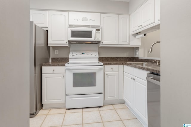 kitchen featuring dark countertops, white cabinets, appliances with stainless steel finishes, and a sink