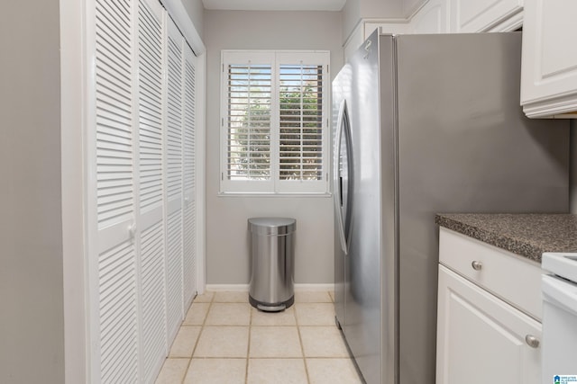 laundry area with laundry area, light tile patterned flooring, and baseboards