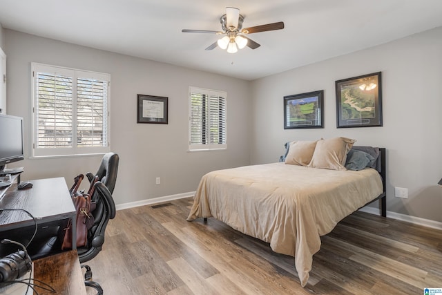 bedroom featuring visible vents, baseboards, light wood finished floors, and ceiling fan