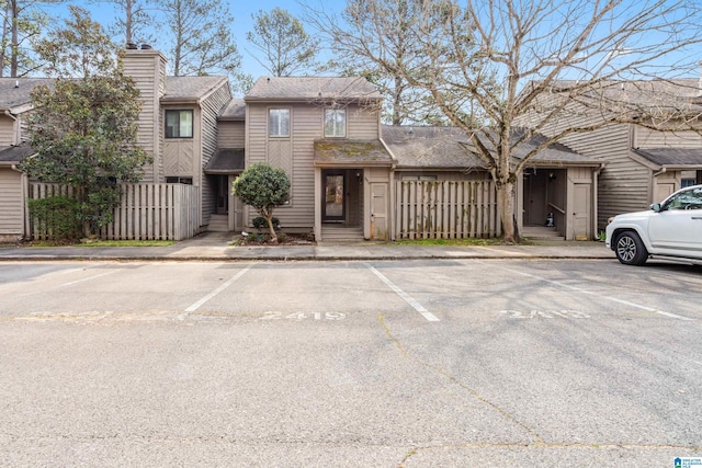 view of property featuring uncovered parking and fence