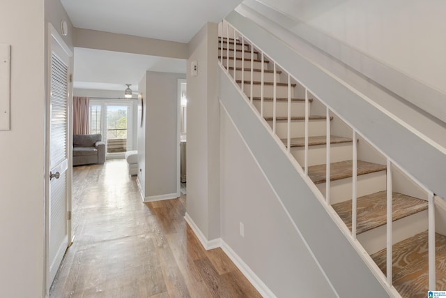 stairway featuring wood finished floors and baseboards