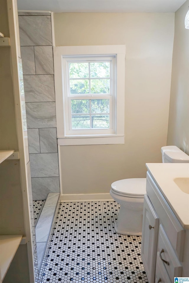 3459 35th Ave N, Birmingham, AL 35207 - full bathroom featuring tile patterned floors, toilet, a tile shower, baseboards, and vanity
