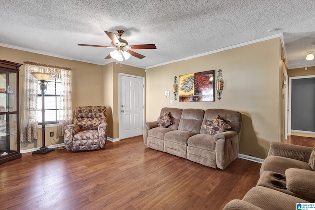 living area with baseboards, ceiling fan, ornamental molding, wood finished floors, and a textured ceiling