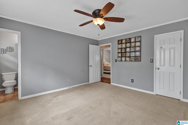 unfurnished bedroom featuring baseboards, carpet, crown molding, and a textured ceiling