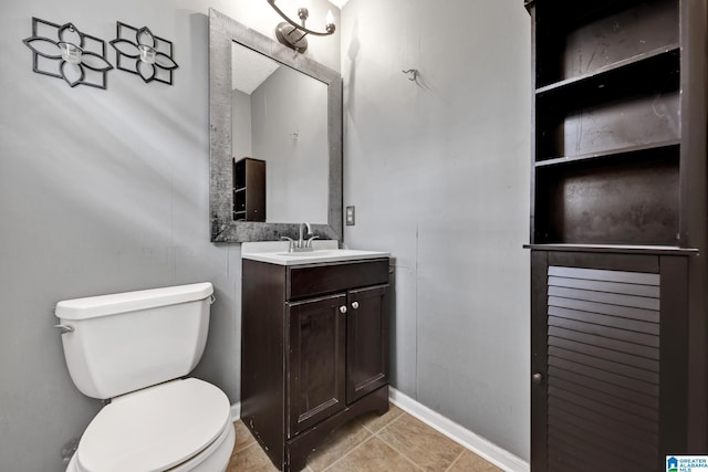 bathroom featuring vanity, toilet, and baseboards