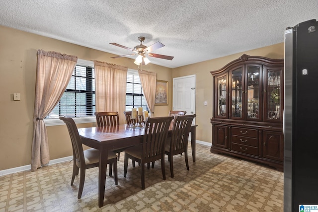 dining area with a ceiling fan, light floors, baseboards, and a textured ceiling