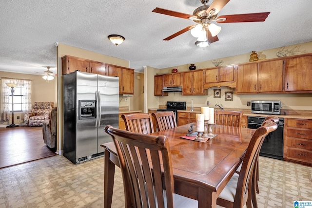 dining room featuring a textured ceiling, light floors, and ceiling fan