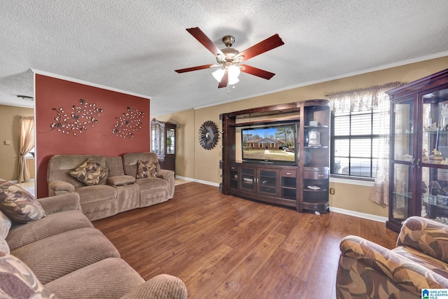 living room featuring a textured ceiling, crown molding, wood finished floors, and ceiling fan