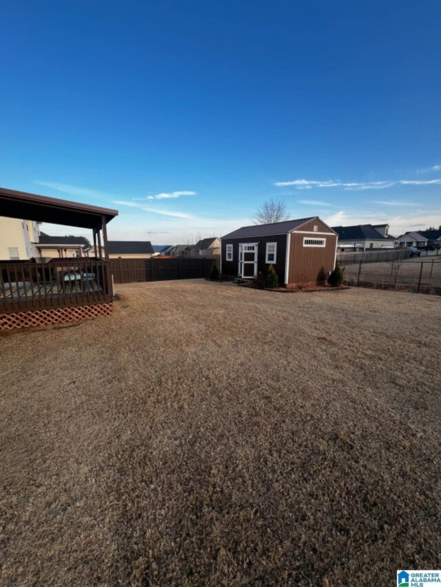 view of yard featuring an outdoor structure, a fenced backyard, and a wooden deck