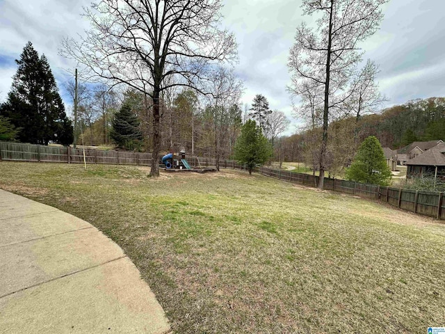 view of yard with a fenced backyard and a playground