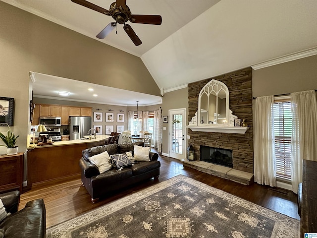 living room featuring a ceiling fan, crown molding, a healthy amount of sunlight, and vaulted ceiling