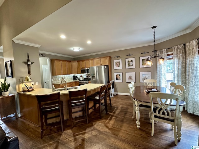 kitchen featuring dark wood-type flooring, a peninsula, a sink, and stainless steel appliances