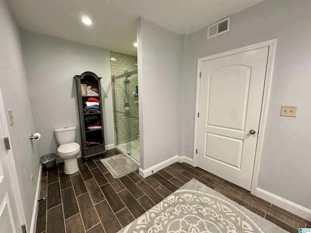 full bathroom featuring toilet, baseboards, a shower stall, visible vents, and wood tiled floor