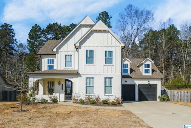 modern farmhouse style home featuring board and batten siding, a shingled roof, driveway, and fence