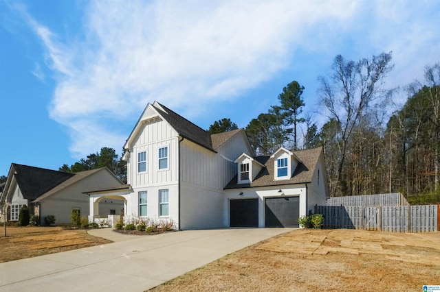 modern farmhouse style home featuring board and batten siding, concrete driveway, a garage, and fence