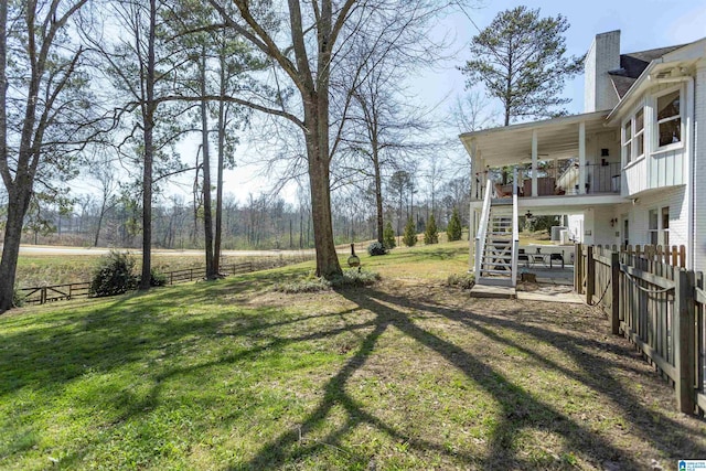 view of yard featuring stairway and fence