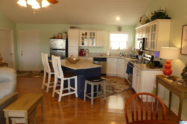 1310 County Road 264, Wedowee, AL 36278 - kitchen featuring wood finished floors, a center island, white cabinetry, appliances with stainless steel finishes, and a breakfast bar area