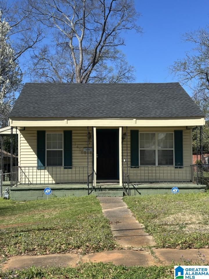 bungalow-style home featuring a porch and roof with shingles