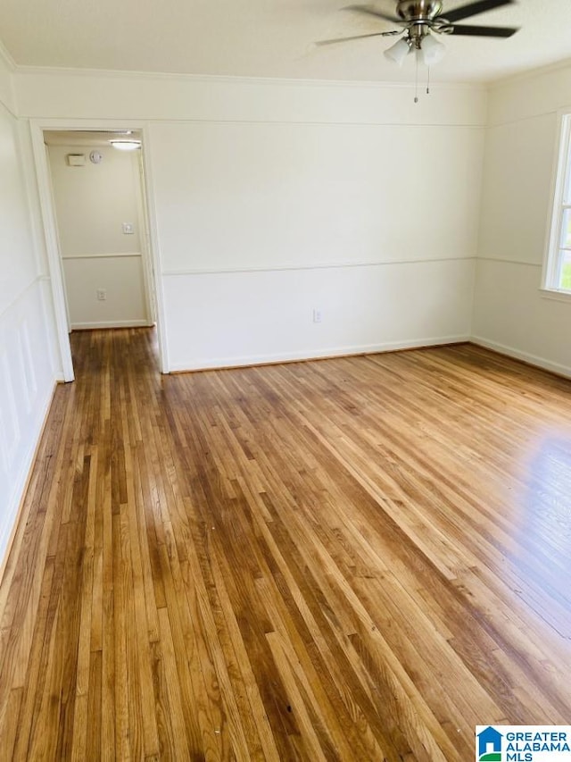 empty room with ceiling fan, crown molding, and hardwood / wood-style flooring