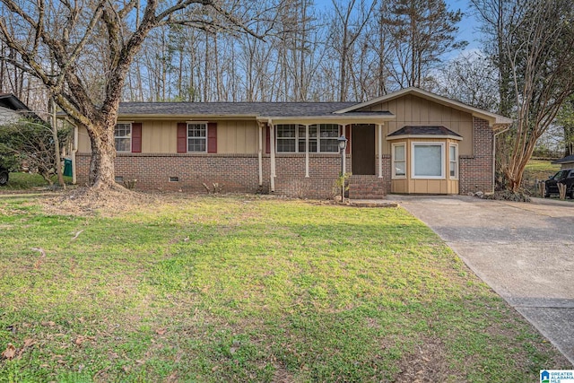 single story home featuring brick siding, board and batten siding, concrete driveway, and a front yard