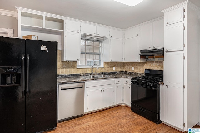 kitchen with dark countertops, under cabinet range hood, light wood-style flooring, black appliances, and a sink