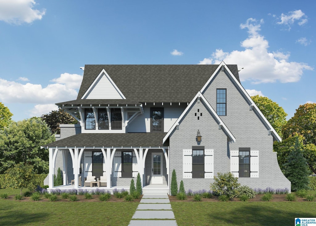 view of front of property with covered porch, a shingled roof, and a front lawn