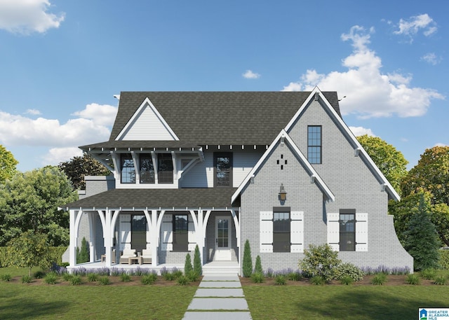 view of front of property with covered porch, a shingled roof, and a front lawn